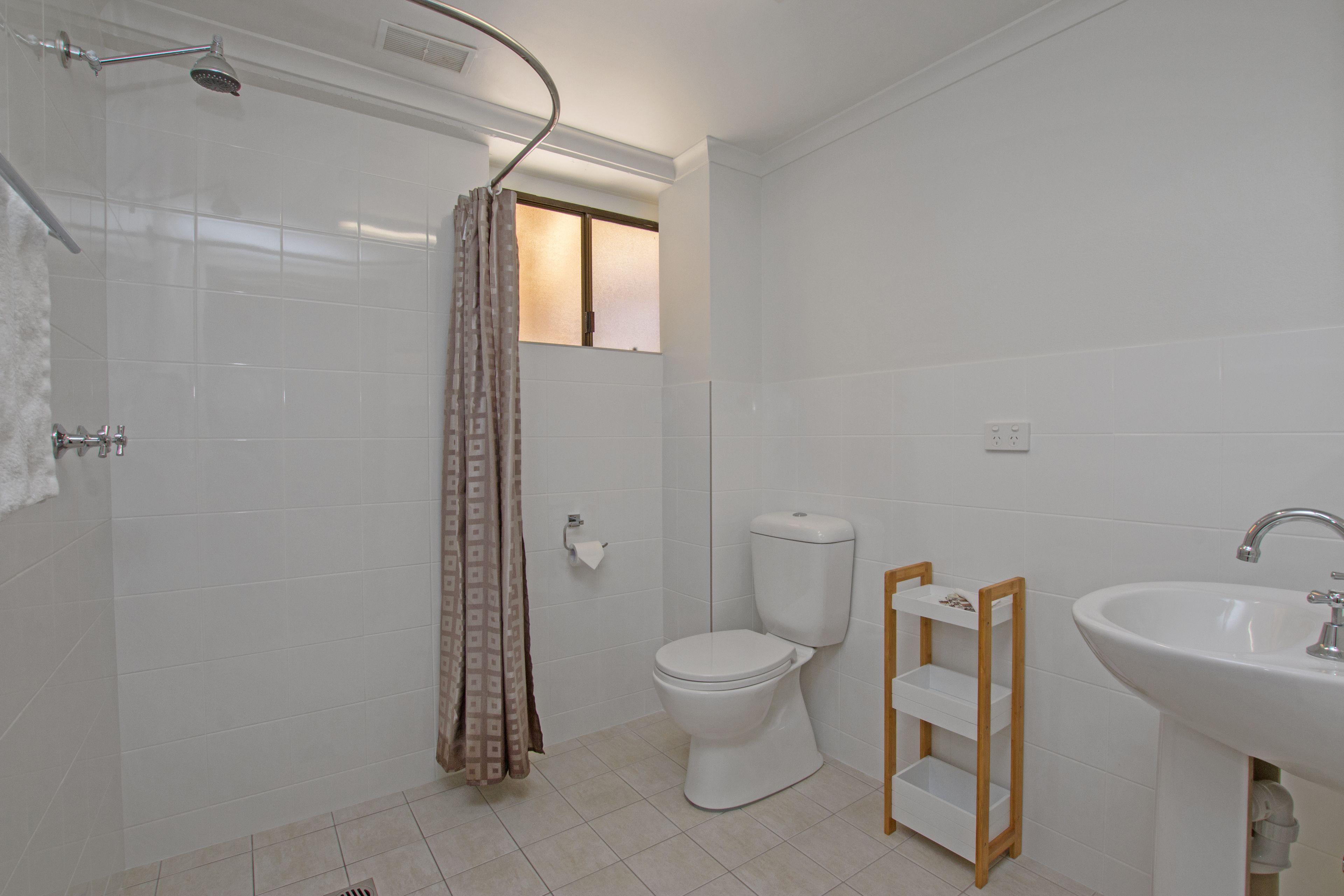 A bathroom with a shower, toilet, and sink.