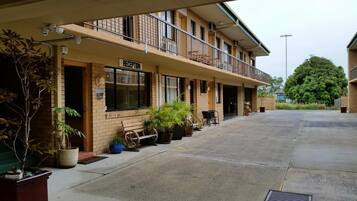 A building with a reception area, a balcony, and potted plants.