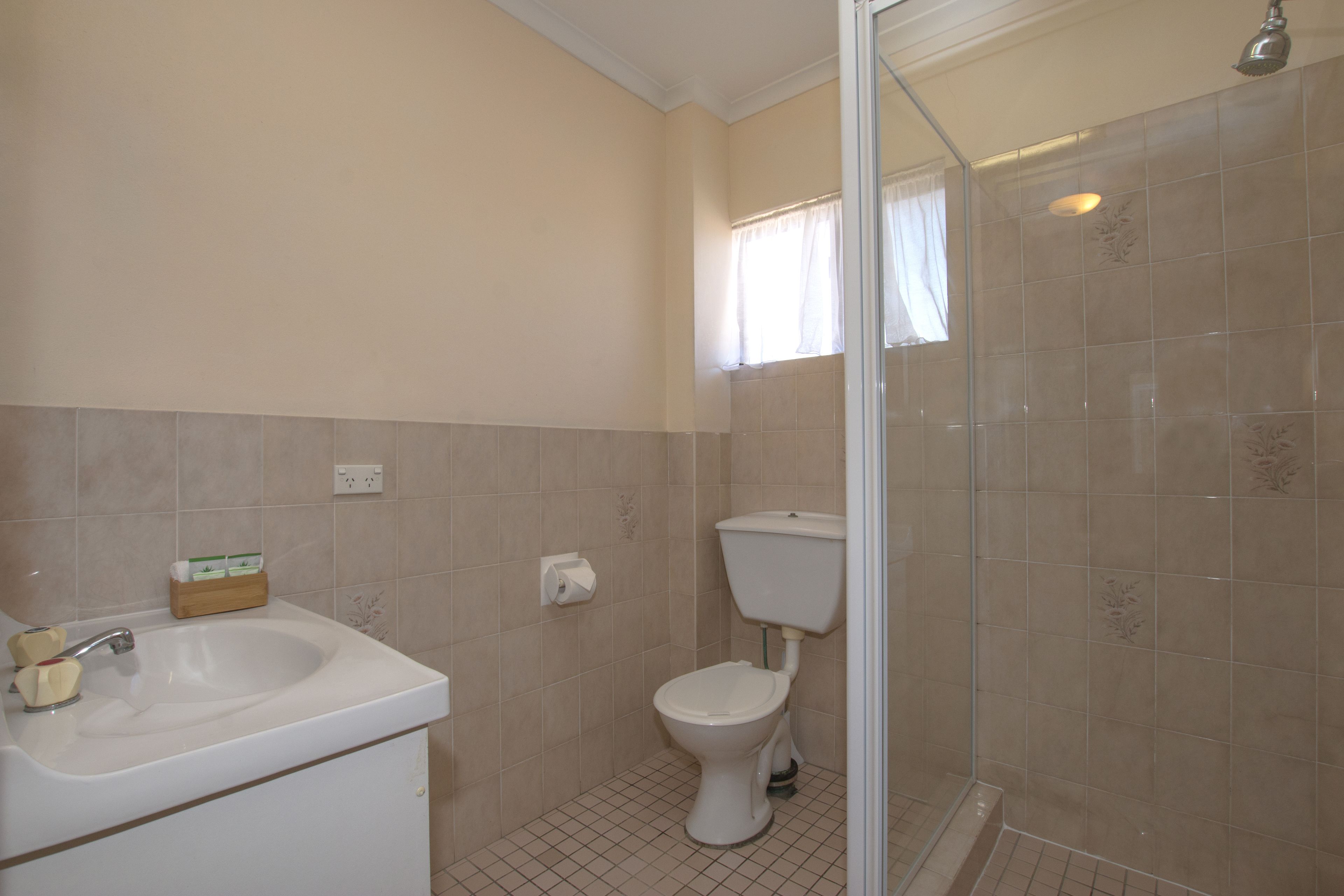 A bathroom with a sink, toilet, and shower.