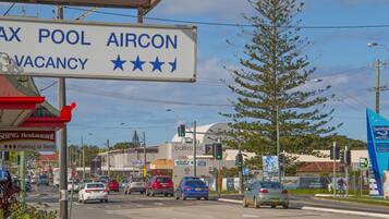A street view with a sign for a pool aircon vacancy.
