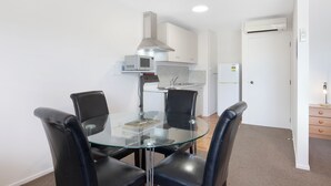 Een moderne keuken met witte kasten, een magnetron en een inbouwoven.