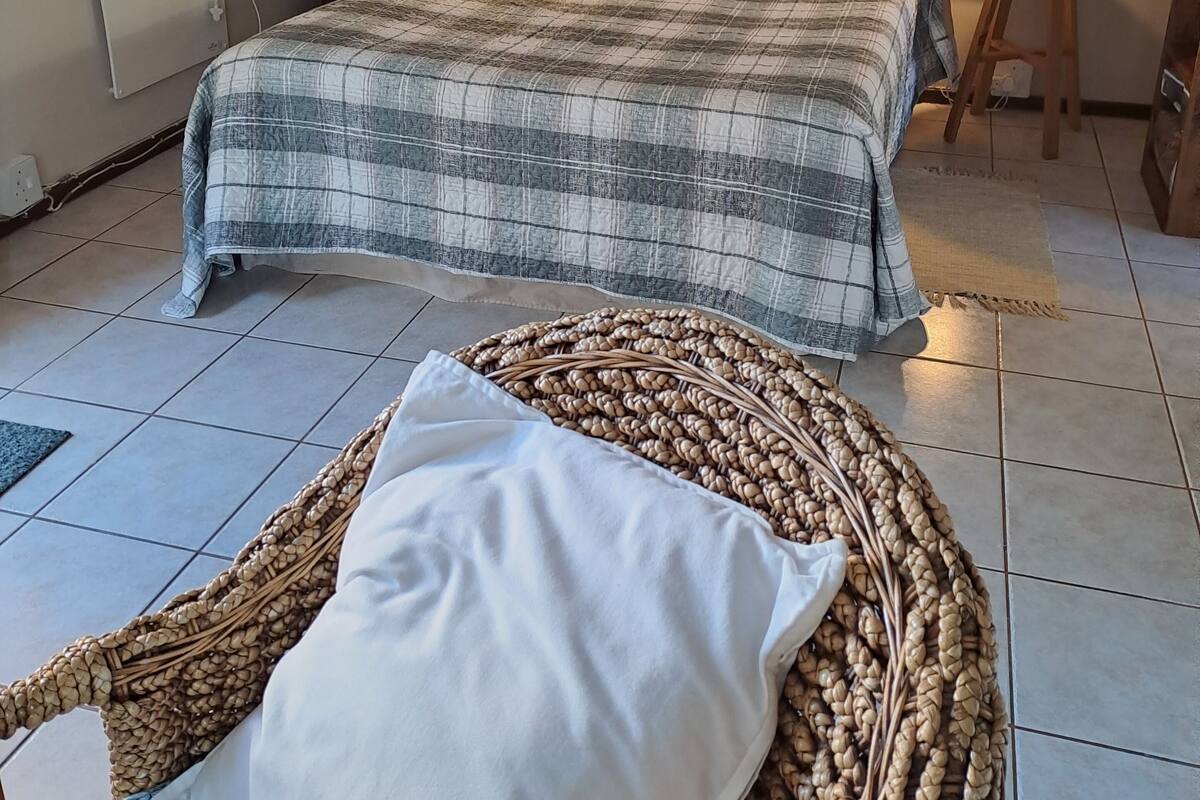 A bedroom with a large bed, a bedside table, a small round table, and decorative wall art.