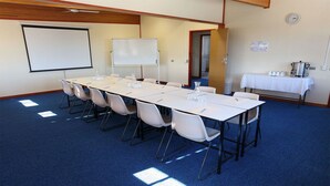 A conference room with a long table, chairs, a whiteboard, and a coffee station. - Maryborough Motel and Conference Centre (Maryborough)