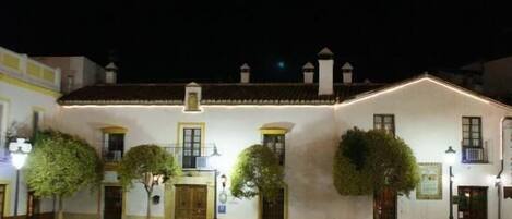 Vista frontal de la propiedad por la tarde o noche