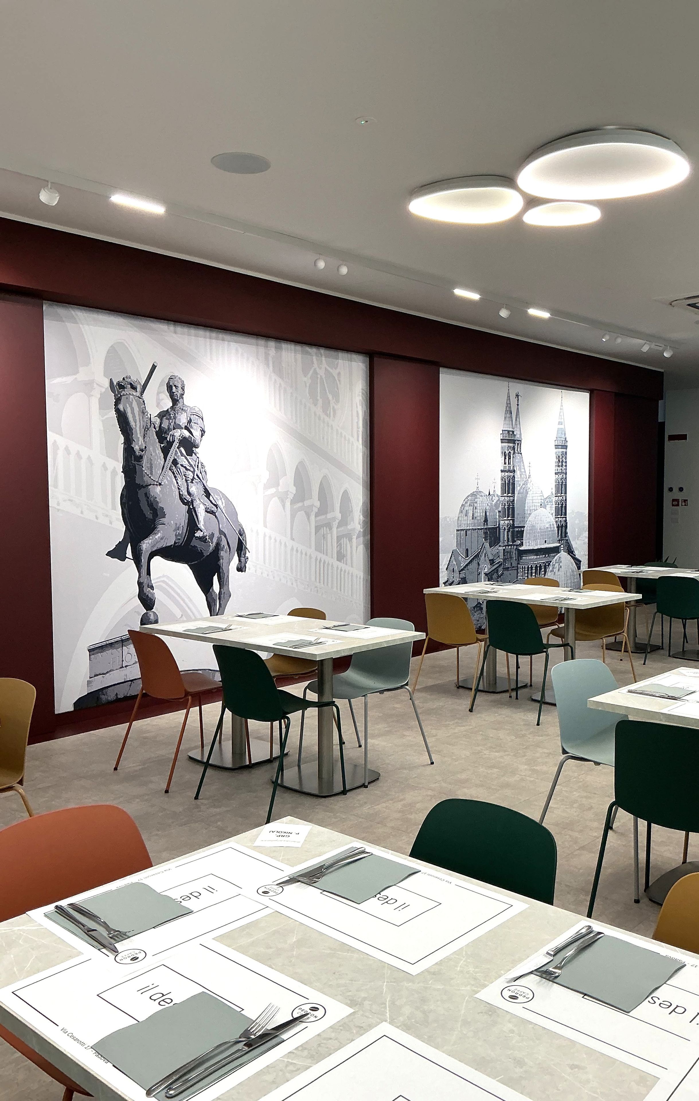 A conference room with tables, chairs, and a large wall mural.