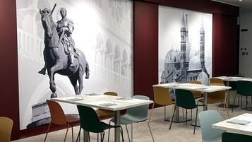 A conference room with tables, chairs, and a large wall mural.