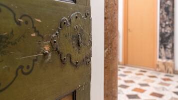 Primer plano de una puerta de madera con ornamentales tallados y bisagras metálicas.