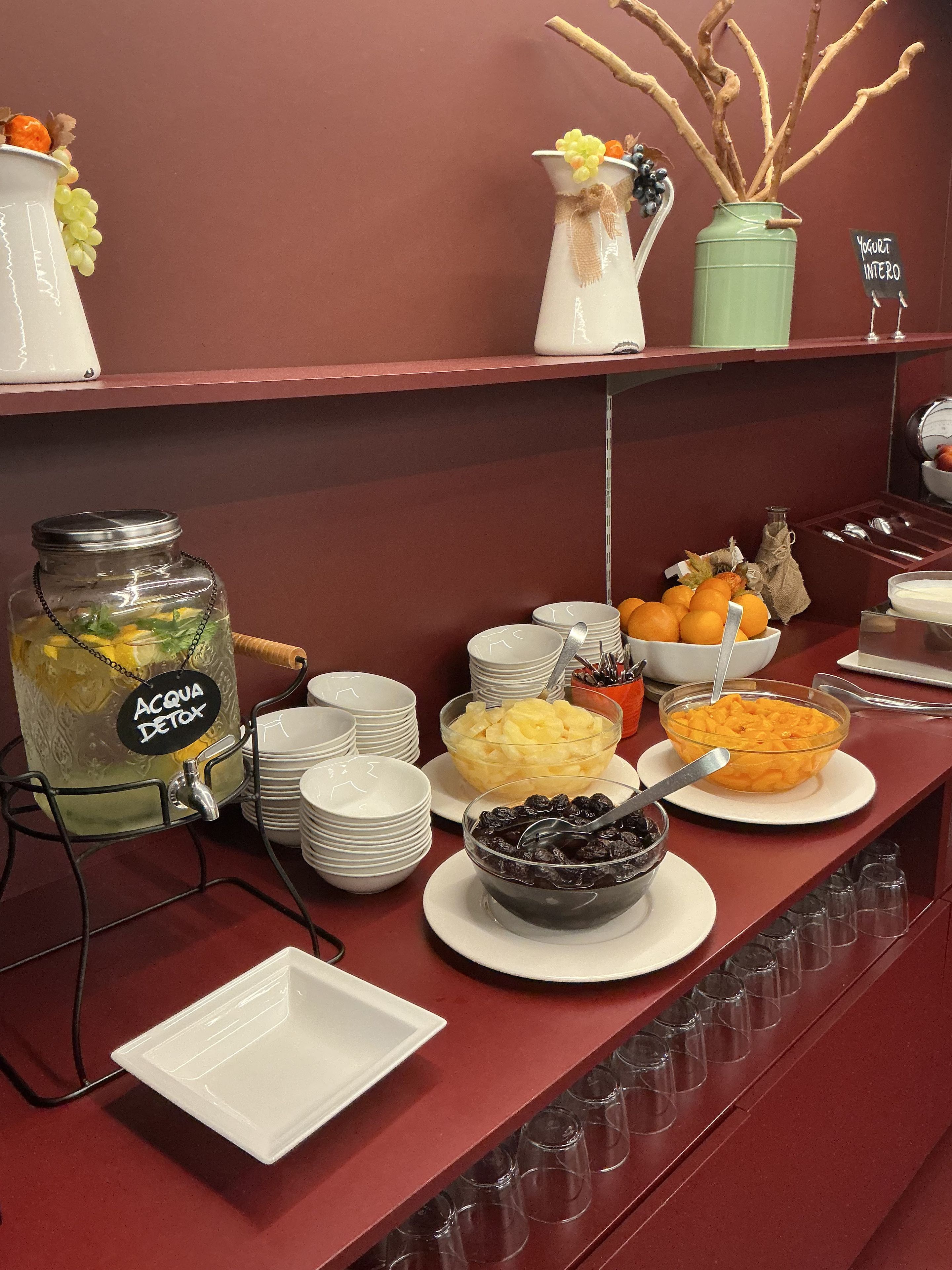 A buffet setup with various food items and a water dispenser.