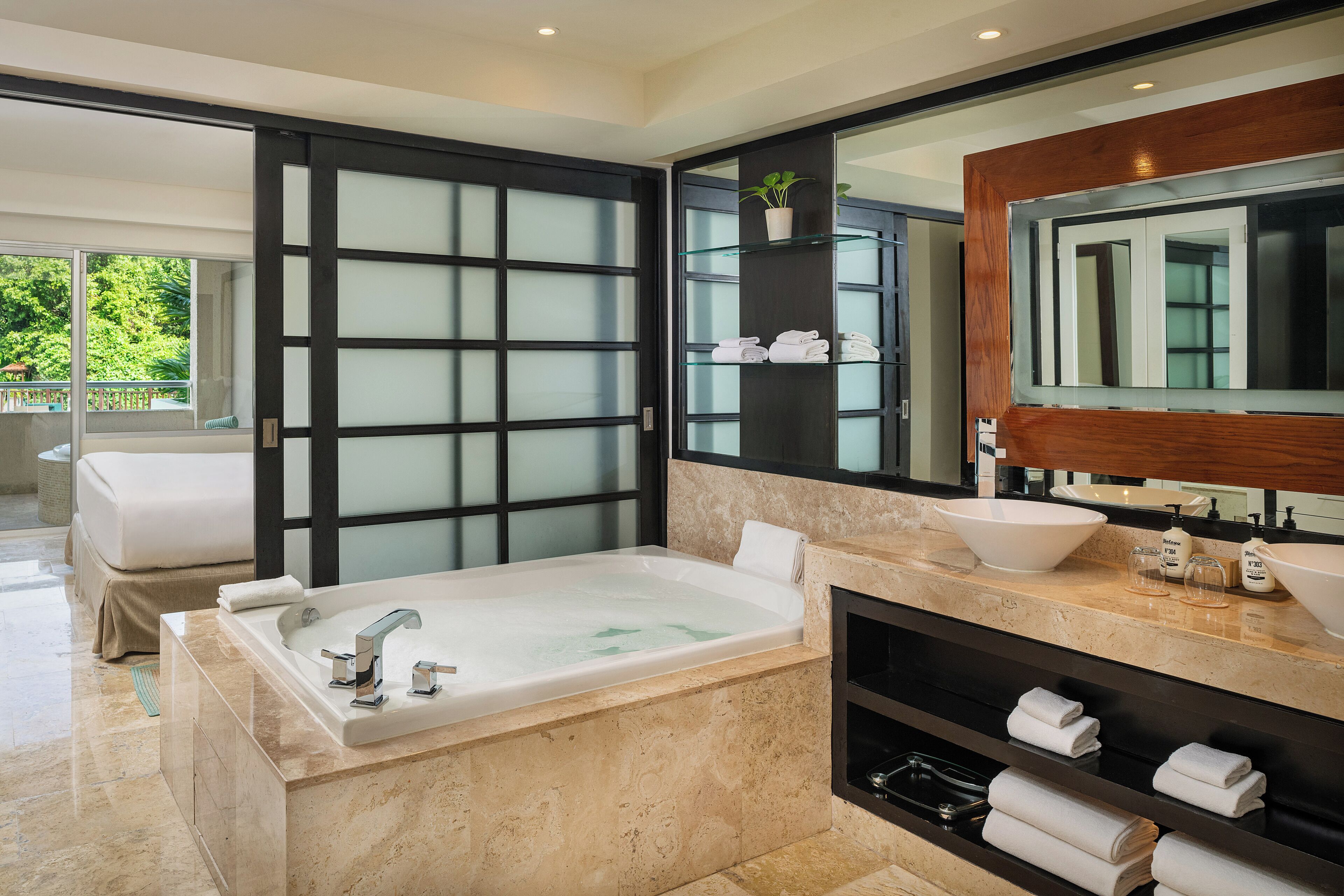 A modern bathroom with a large bathtub, a vanity with a mirror, and a glass shower enclosure.