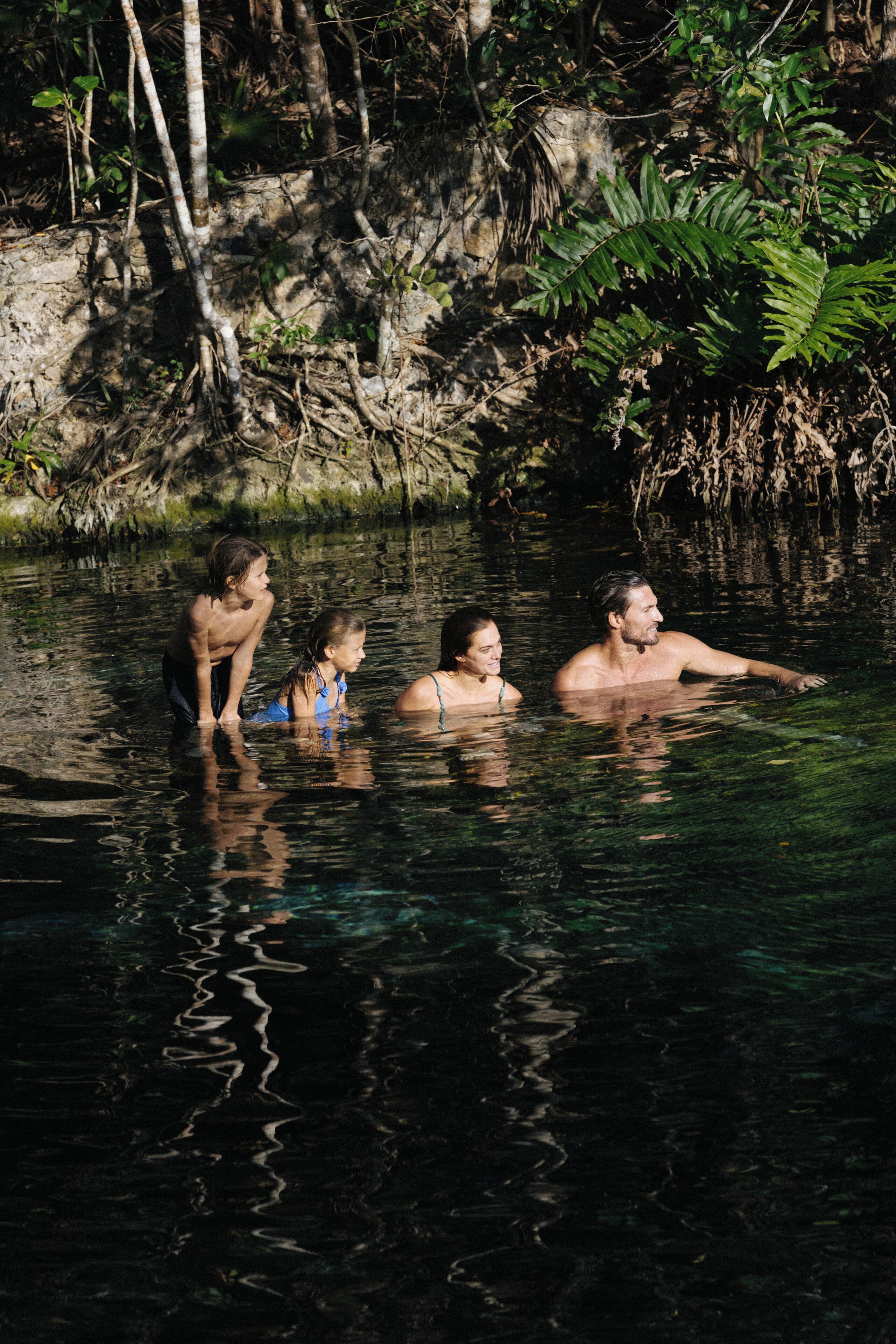 Massa de água natural rodeada por árvores e vegetação.