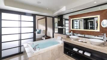 Un bagno moderno con una vasca da bagno ampia, due lavabi e un grande specchio.