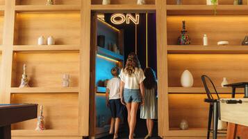 Een houten interieur met planken, een neonbord en een pooltafel.