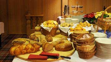 Una mesa de buffet con panes y pasteles variados, cestas y platos.