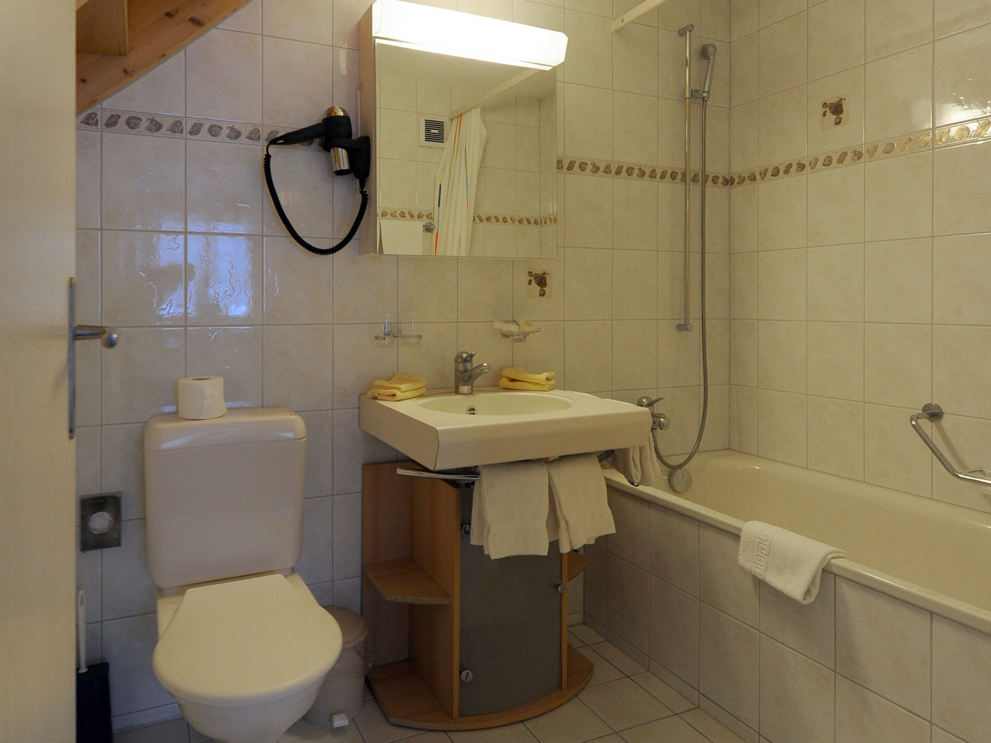 A bathroom with a toilet, sink, and bathtub.