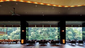A spacious room with large windows, wooden flooring, and modern furniture. - Tsuetate Onsen Hizenya (Oguni)