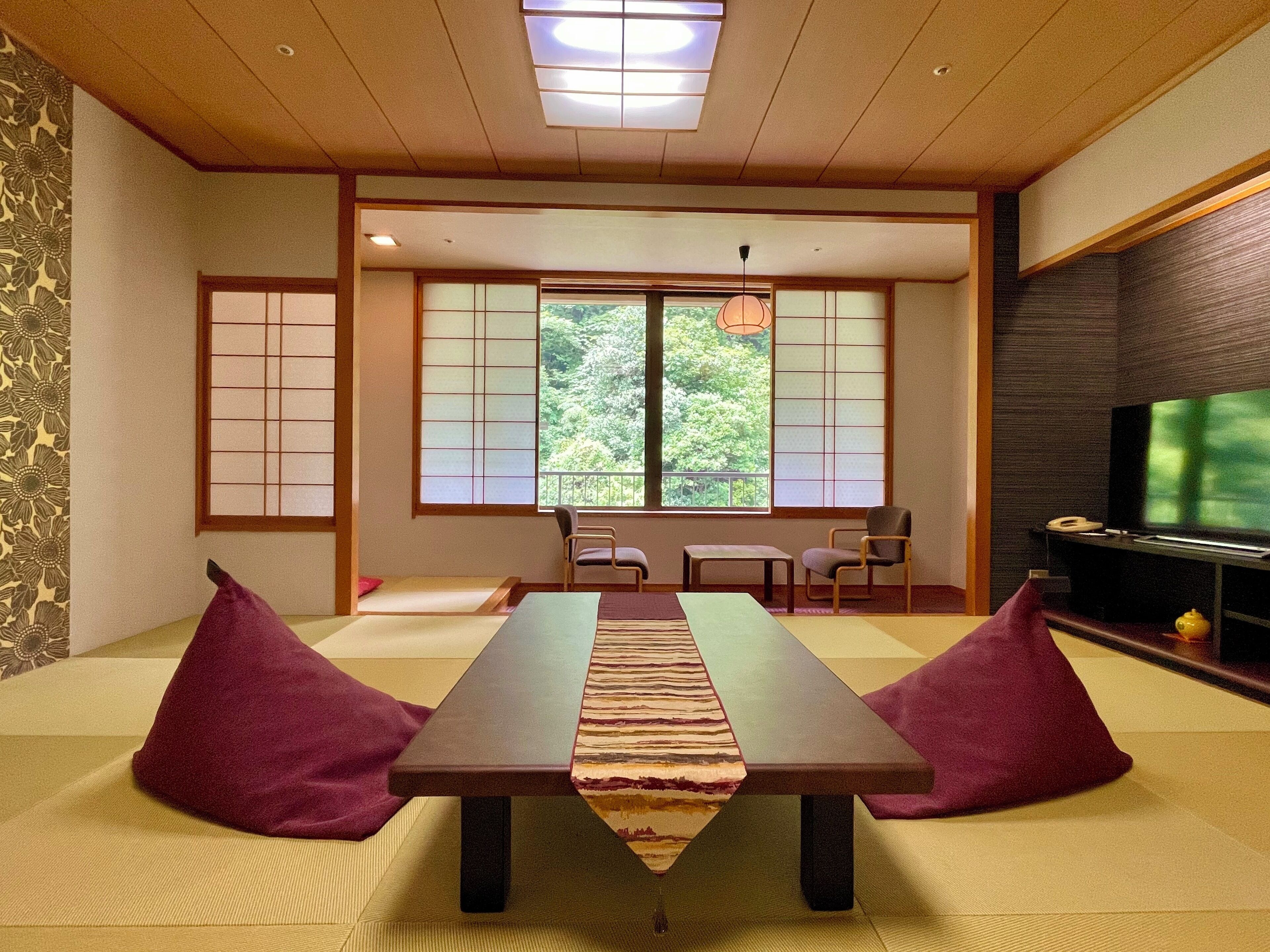 A traditional Japanese room with tatami mats, a low table, and sliding doors.