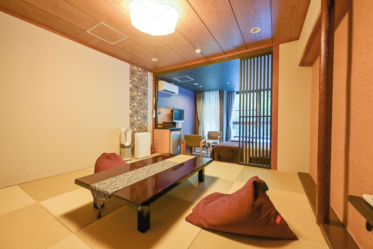 A traditional Japanese-style room with tatami flooring, a low table, and a sliding door leading to a balcony.
