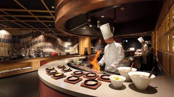 A chef cooking at a counter with a modern kitchen design, including a curved ceiling and wooden accents.