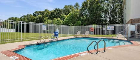 A swimming pool with a safety fence, a lifeguard chair, and a lifebuoy.