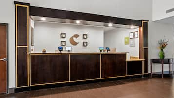 A reception desk with a wooden finish, a large wall-mounted crescent moon decoration, and several framed certificates on the wall.