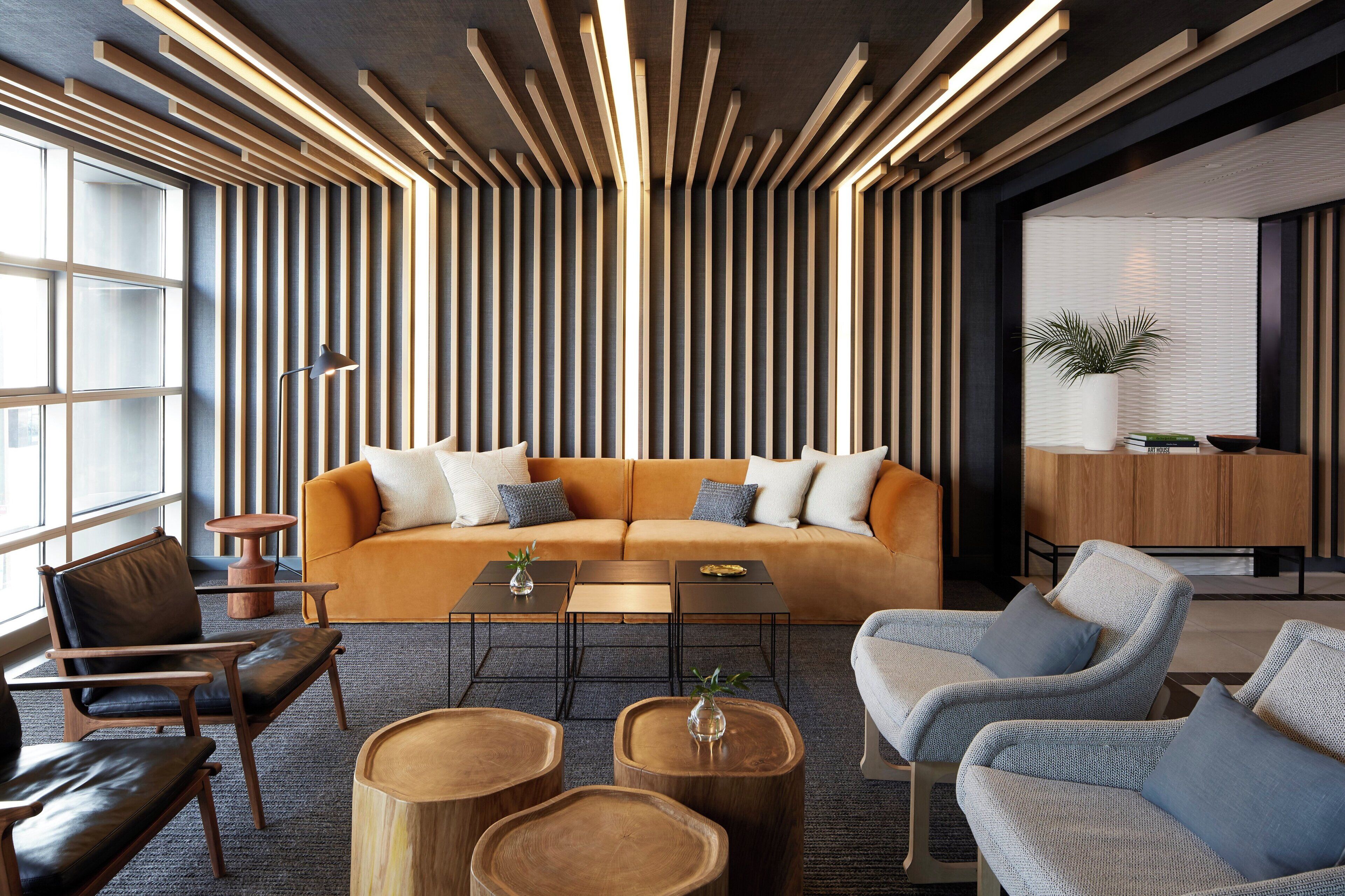A modern interior with a sofa, coffee table, chairs, and a wooden accent wall.