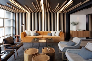 A modern interior with a sofa, coffee table, chairs, and a wooden accent wall.