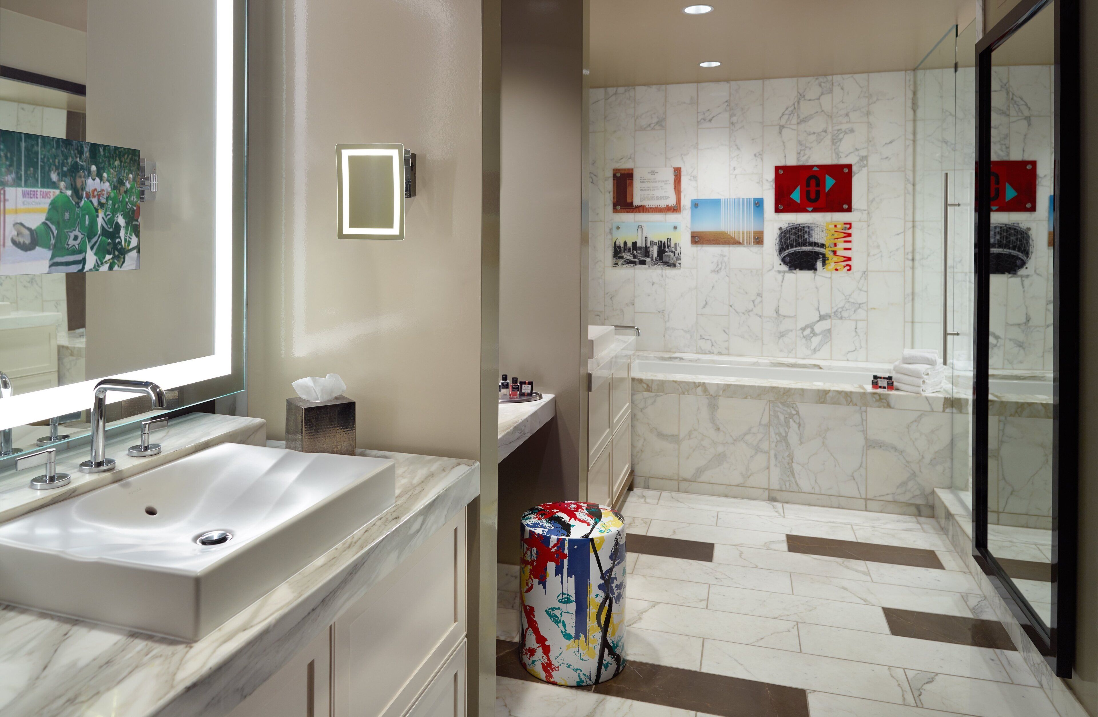 A modern bathroom with a large sink, mirror, and a shower area.