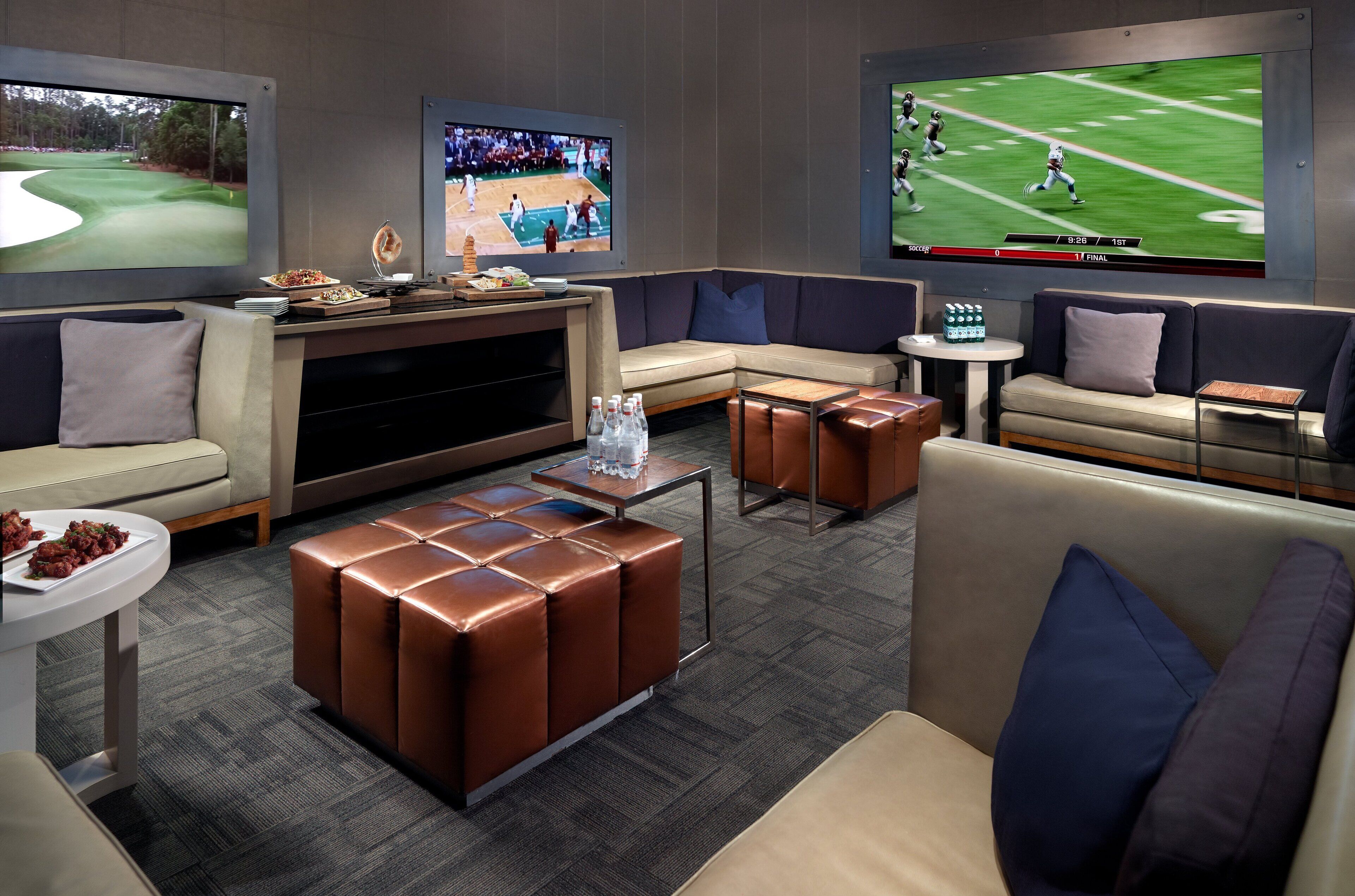 A modern lounge area with a large flat-screen TV, comfortable seating, and a small coffee table.
