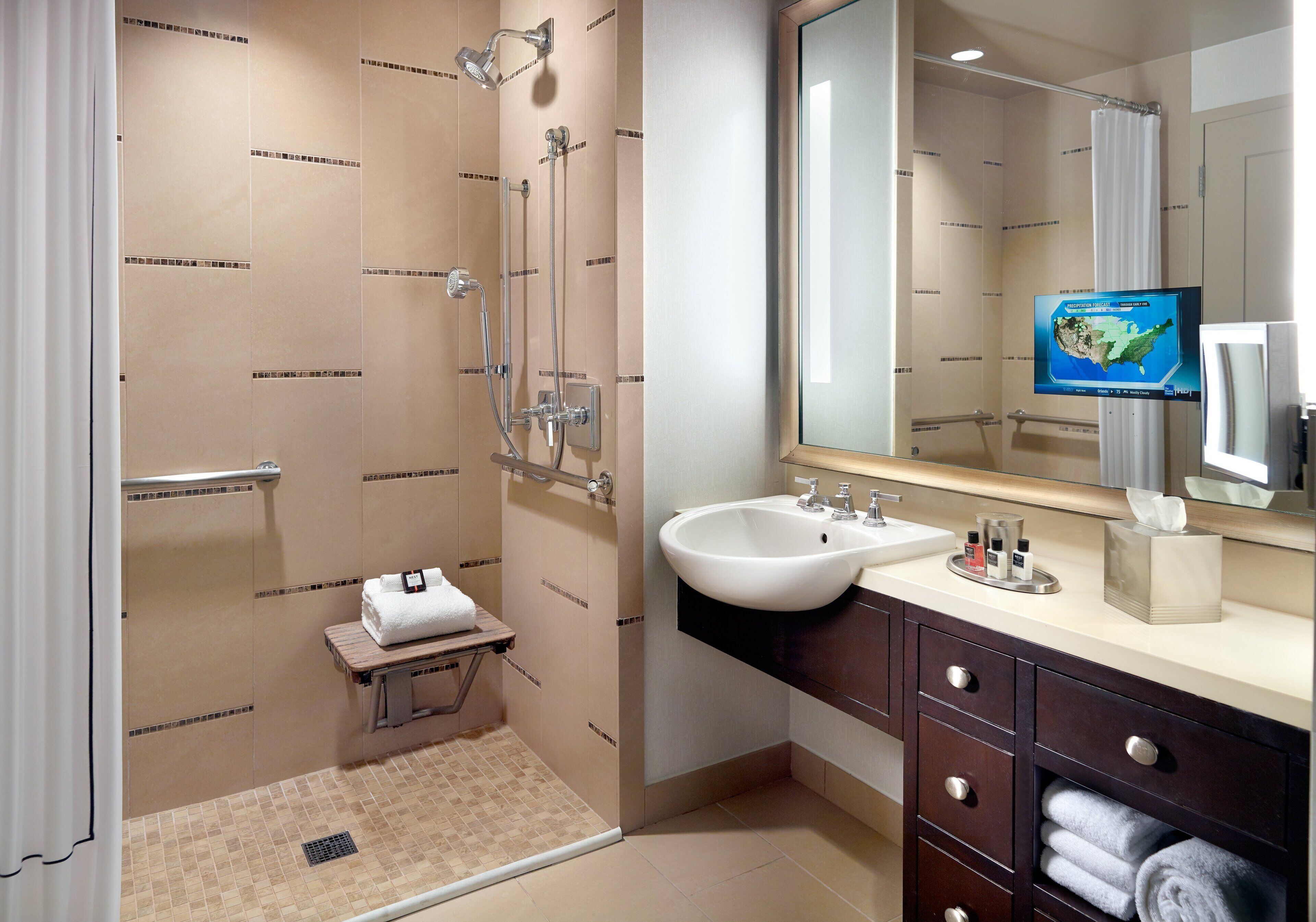 Un baño moderno con ducha, lavabo y tocador.