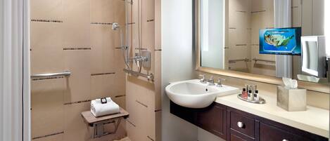 A modern bathroom with a shower, sink, and vanity.