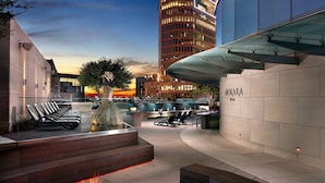 A modern outdoor area with a fire pit, lounge chairs, and a spa sign. - Omni Dallas Hotel (Dallas)