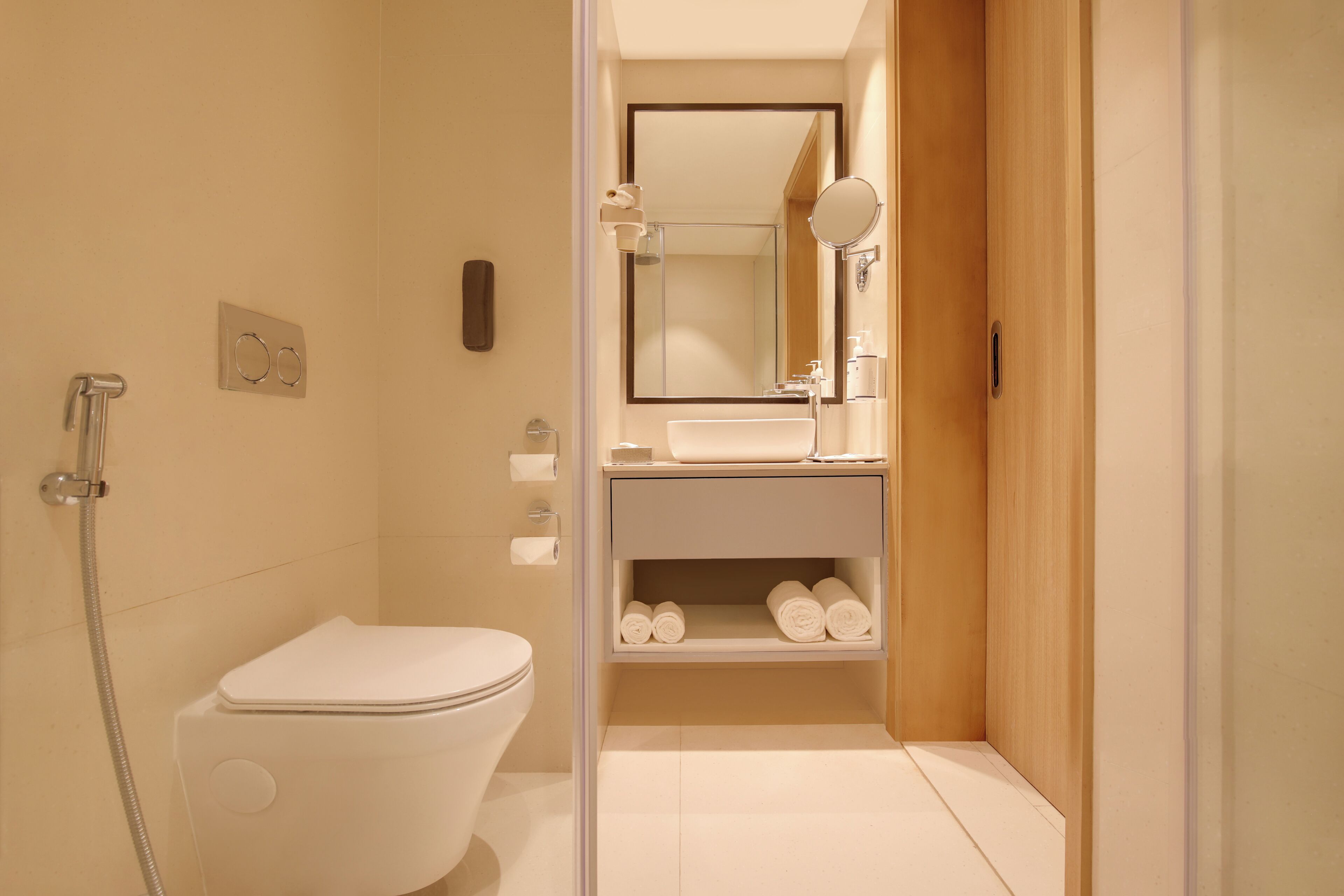Un baño moderno con inodoro, ducha, lavamanos y espejo.