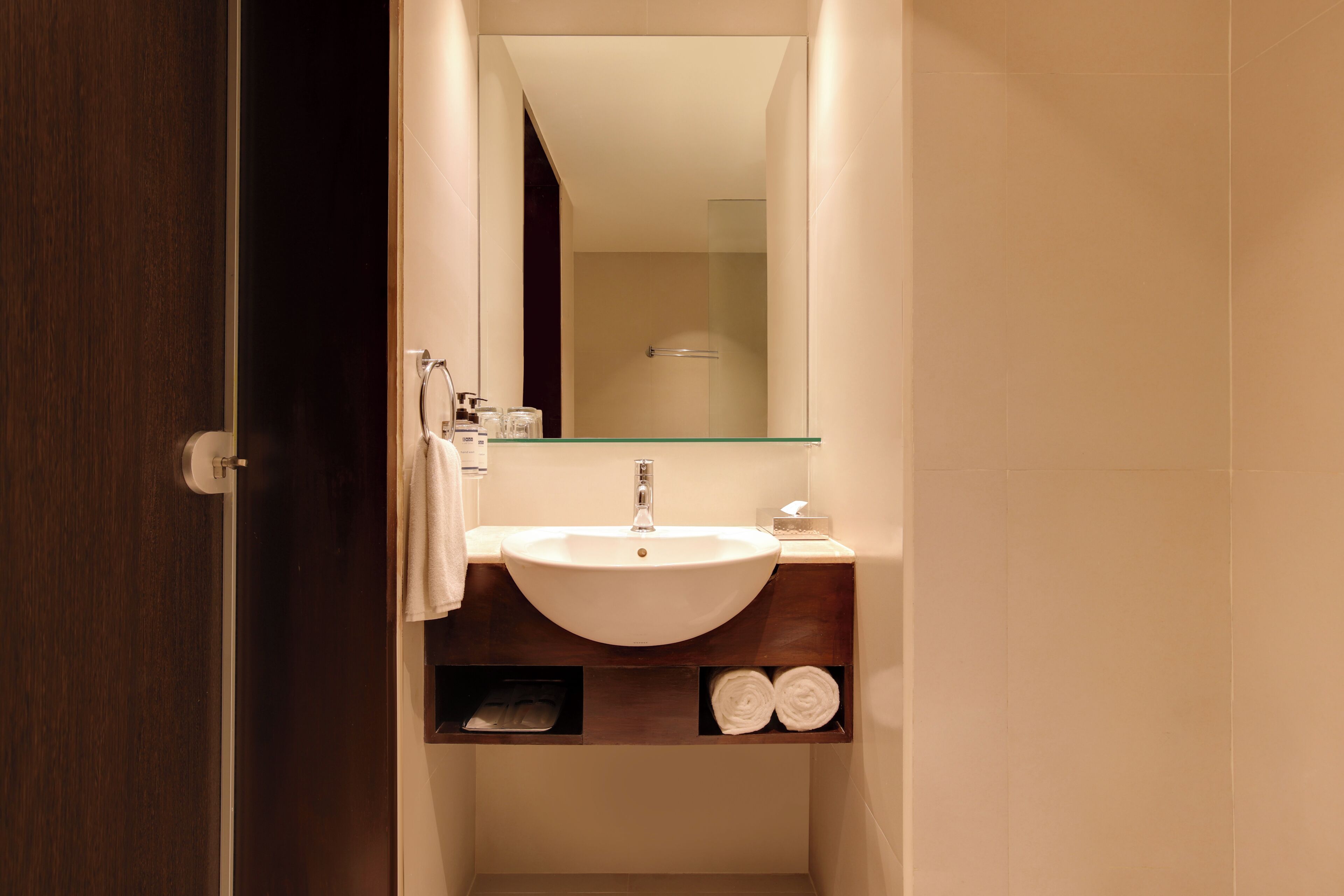 A bathroom with a white sink, a mirror, and a towel rack.
