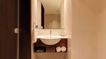 A bathroom with a white sink, a mirror, and a towel rack.