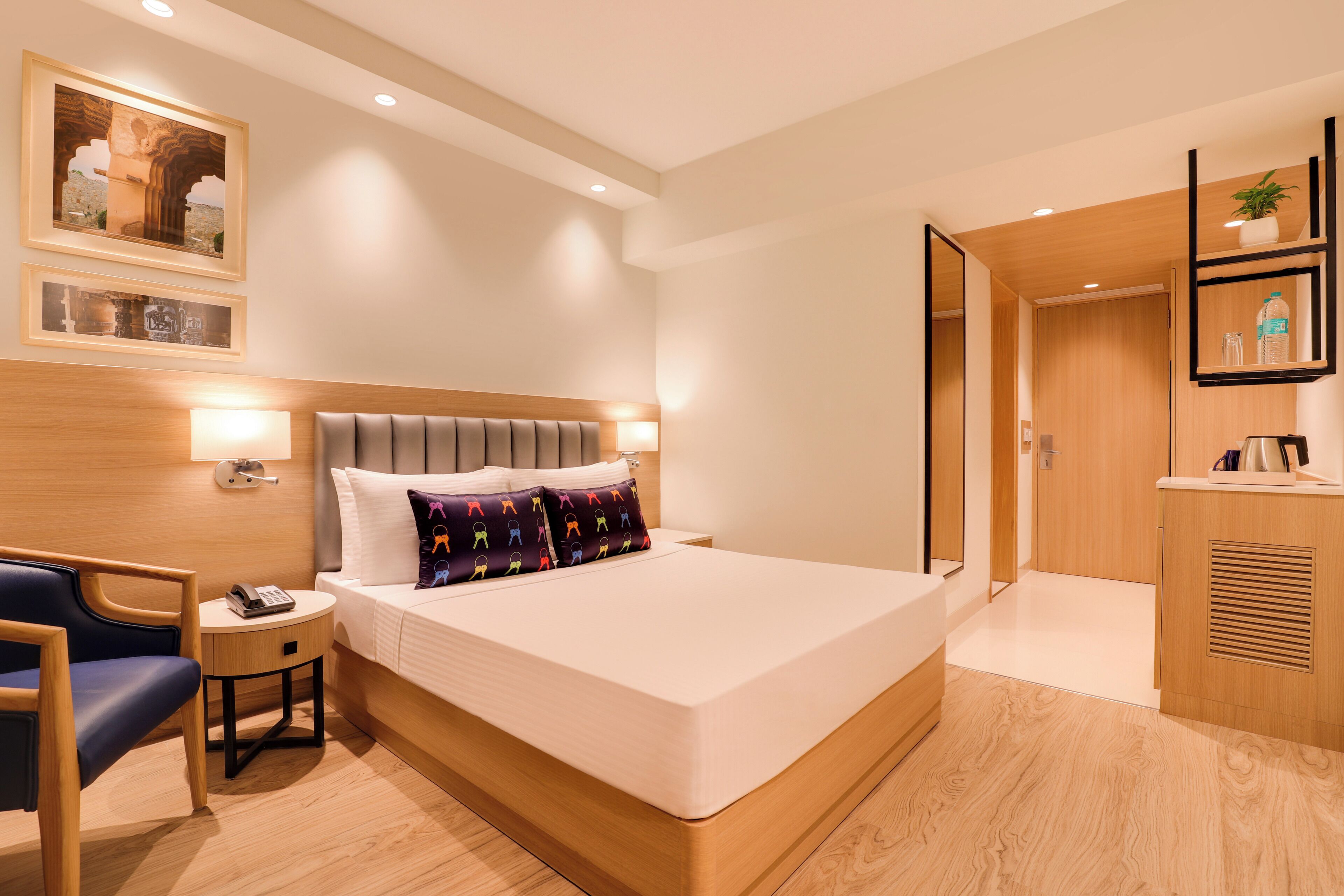 Une chambre d’hôtel moderne avec un grand lit, des tables de chevet, un bureau et une armoire.