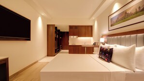 Une chambre d’hôtel avec un lit, une télévision, un bureau et une salle de bain.