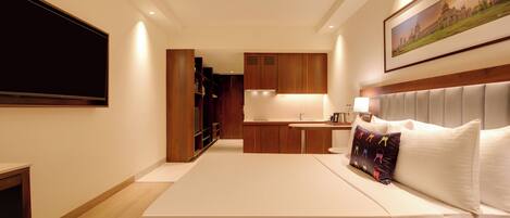Una habitación de hotel con cama, televisor, escritorio y baño.