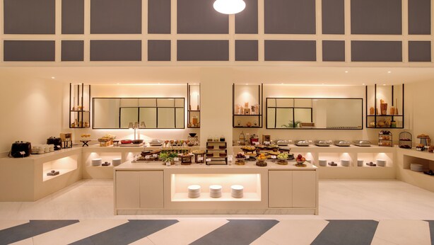 Une cuisine moderne dotée d’un îlot central, d’appareils électroménagers intégrés et de nombreux plans de travail.