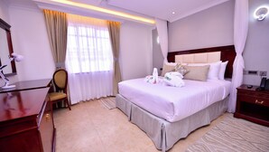 Une chambre d’hôtel avec un grand lit, un bureau et une chaise.
