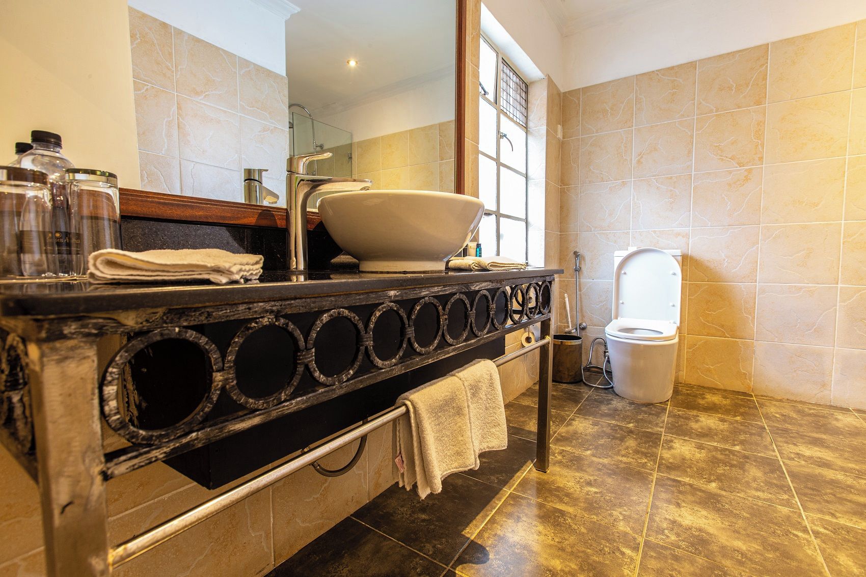 Casa de banho com banheira, sanita e toucador com lavatório e porta-toalhas.