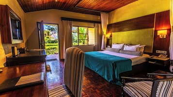 Ein Hotelzimmer mit Bett, Schreibtisch, Stuhl, Fernseher und Blick ins Freie.