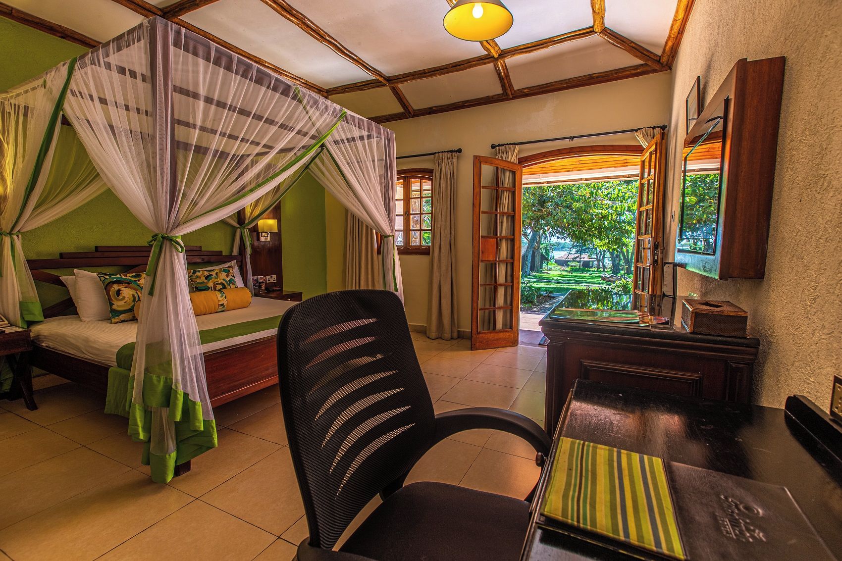 Una habitación con cama, una silla, un escritorio y vistas al exterior.