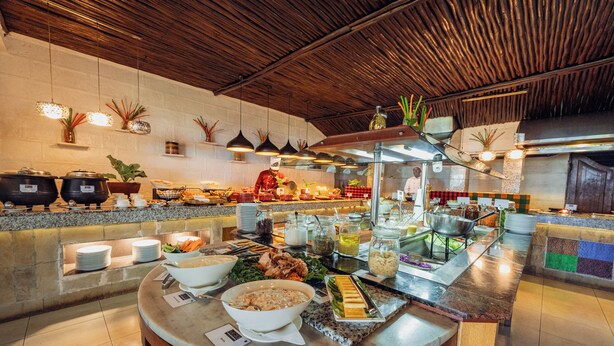 A buffet setup with various food items and a chef preparing food.