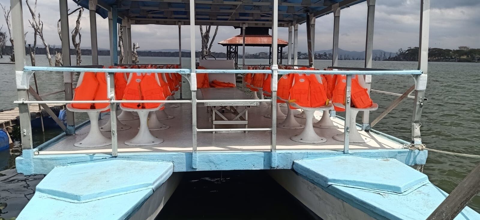 Un pont de bateau équipé de gilets de sauvetage et doté d’un espace de repos abrité.