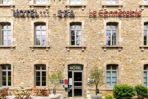 Ein Steinhaus mit einem Schild für HOTEL SPA und Le Connétable.
