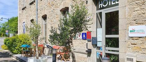 A stone building with a sign reading "HOTEL" and a sign for "BRIT HOTEL".