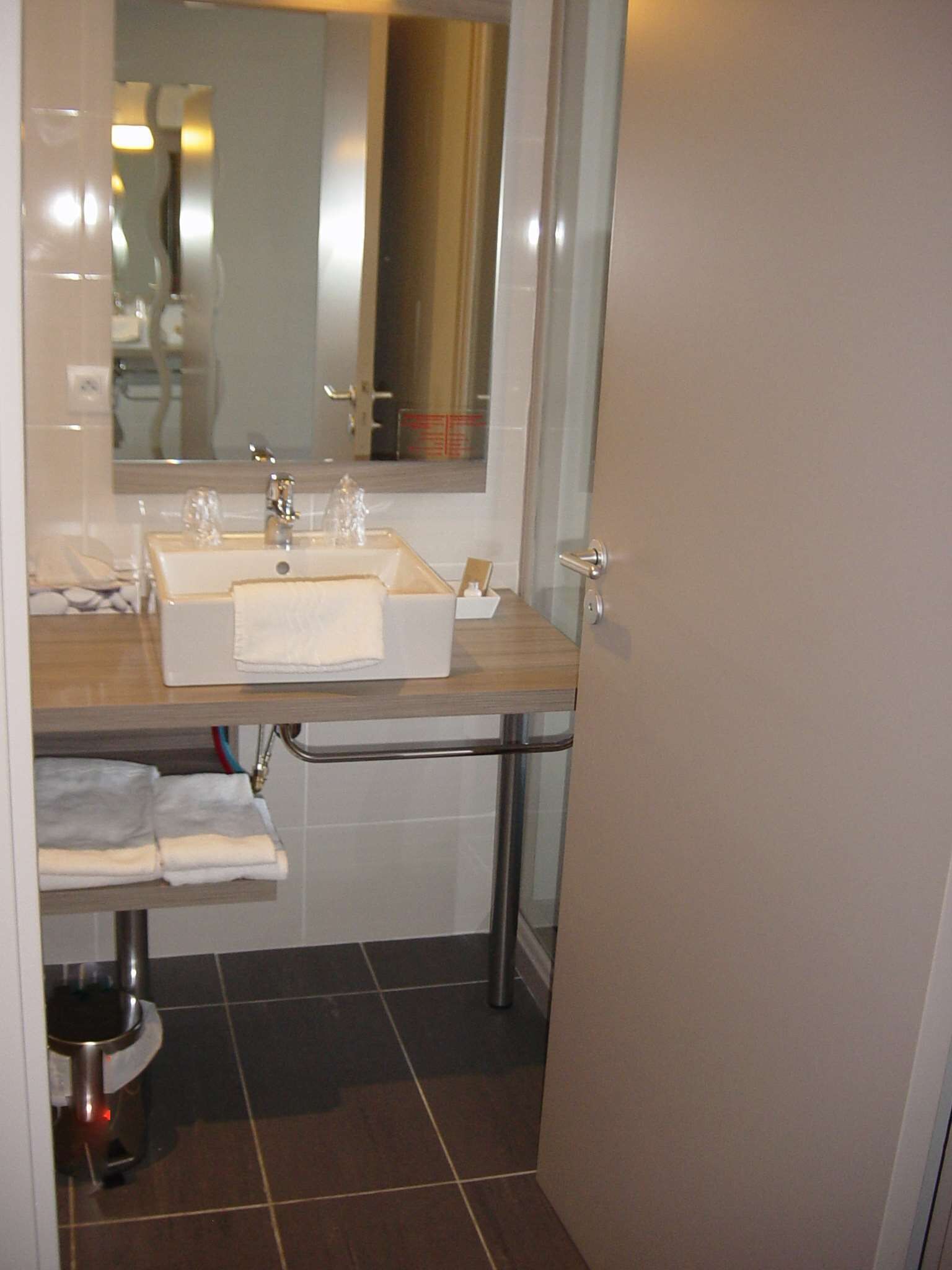 Un baño con lavamanos doble, un espejo y un perchero para toallas.