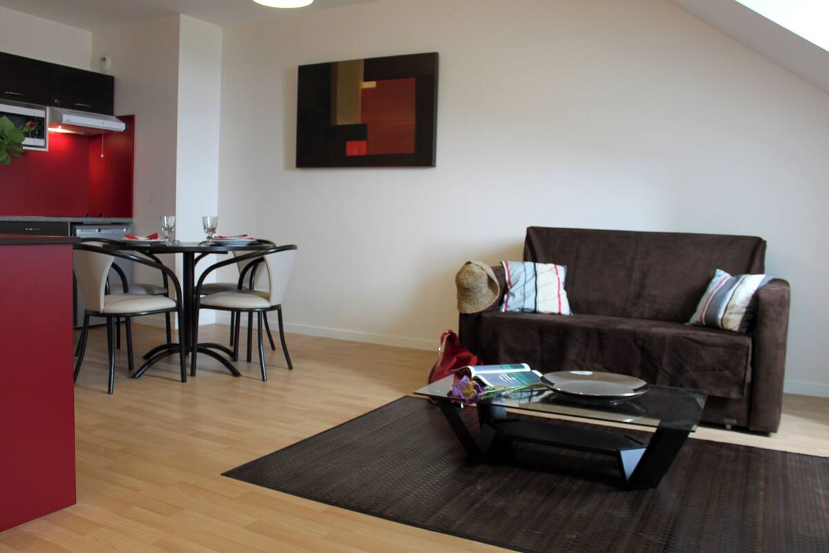 A modern living area with a dining table, chairs, a sofa, and a coffee table.