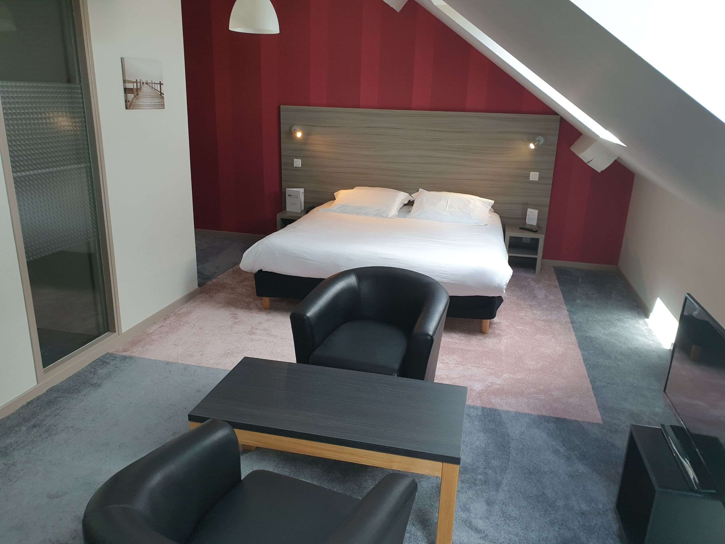 A modern bedroom with a bed, a desk, and a chair.