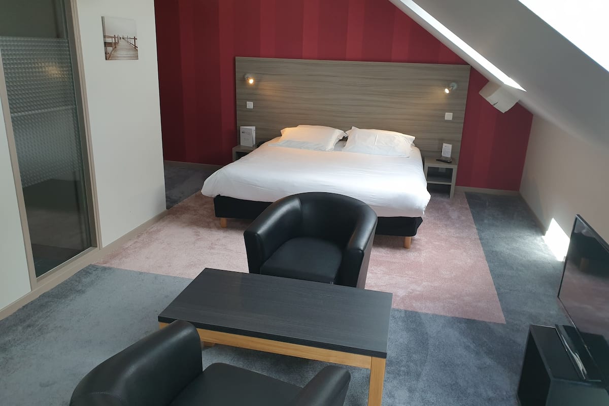 A modern bedroom with a bed, a desk, and a chair.